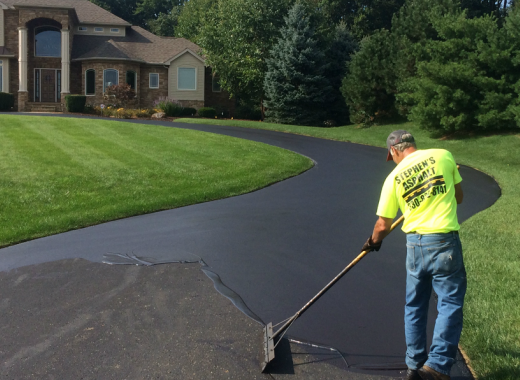 Stephen's Asphalt crew member sealcoating a residential driveway in Massillon, Ohio
